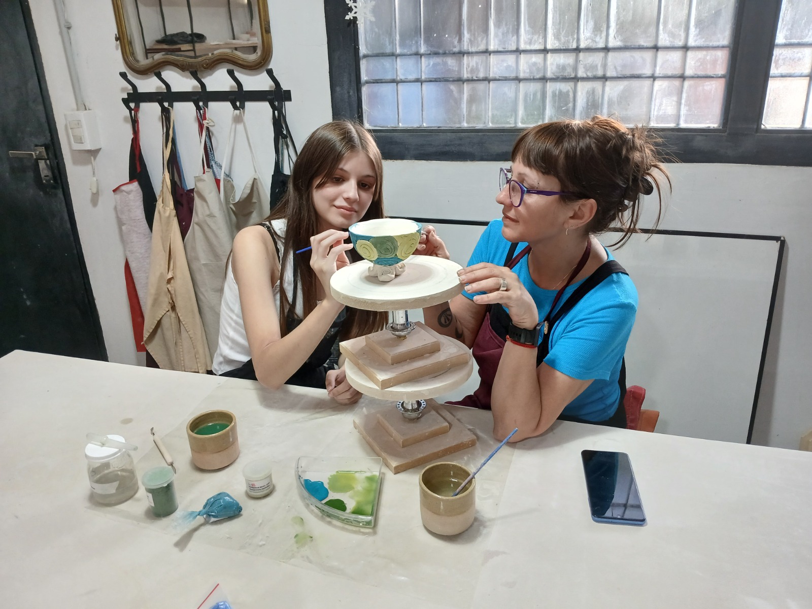 Una alumna trabajando una pieza de cerámica en el taller
